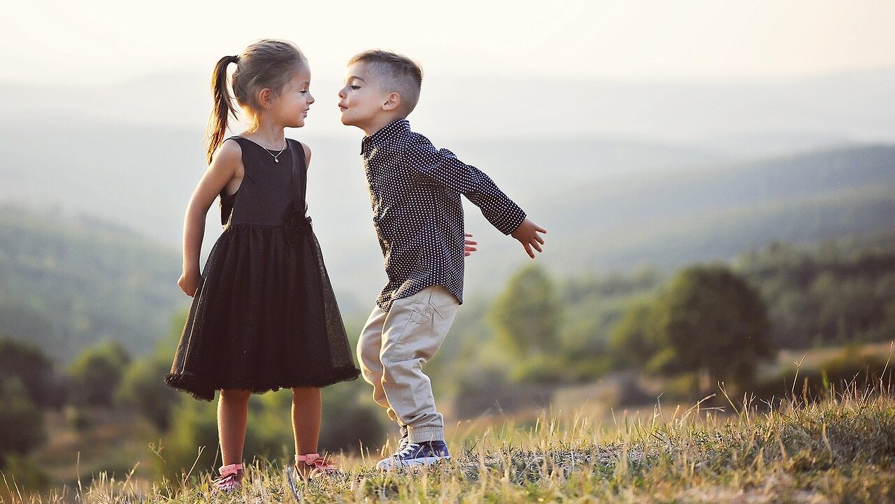 Foto Blog innere Kinder: zwei Kinder auf einer Wiese einander zugewand